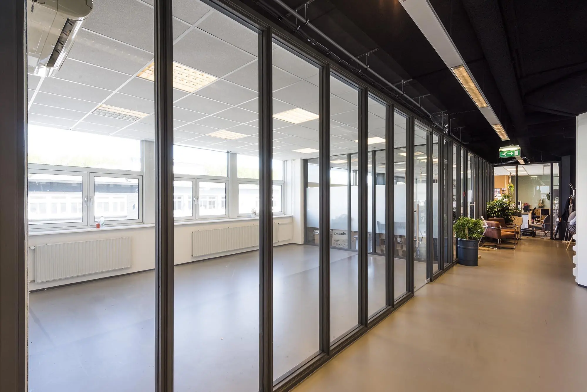 Moderne kantoorruimte aan de Anthony Fokkerweg met glazen wanden en zicht op een lege vergaderruimte.